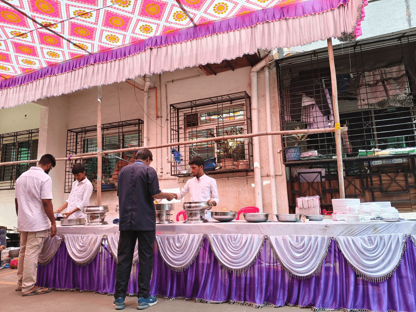 Pav bhaji being prepared at a live counter with bubbling bhaji and butter, dim event lighting